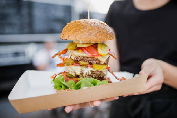 istock Holding Huge triple burger with cheese. 1185246839