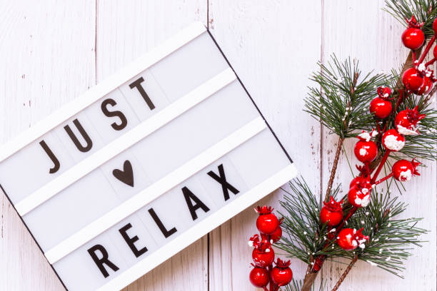 istock Light box with text Just relax and decorative Christmas evergreen branch and Berries on light rustic wooden background. 1185247947