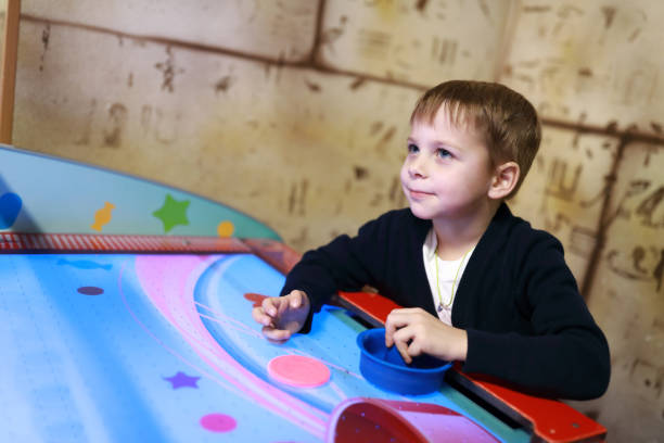 istock Happy boy playing in air hockey 1185249492
