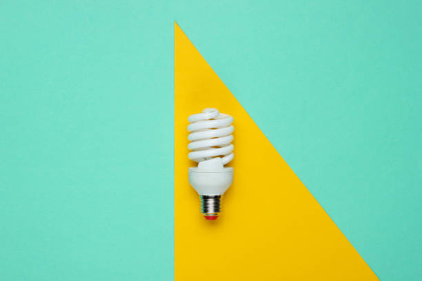 istock Spiral eco light bulb on a colored paper background. Top view. Minimalistic still life 1185249873