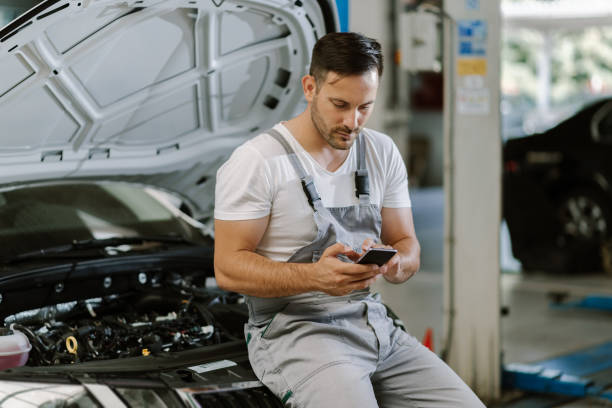 istock Auto mechanic using mobile phone in a repair shop 1185250205