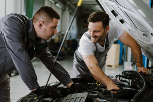 istock Auto mechanics examining a car engine in a repair shop 1185250575
