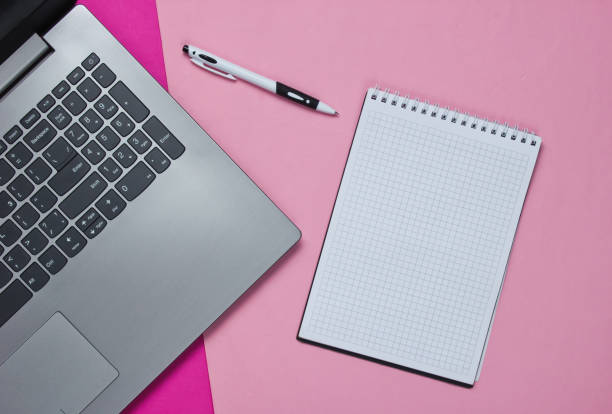 istock Laptop, notebook with pen on a colored paper background. Top view. Studio shot 1185250879