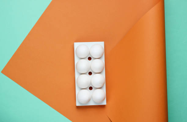 istock Tray with white chicken eggs on colored background. Minimalistic food concept. Top view 1185251143