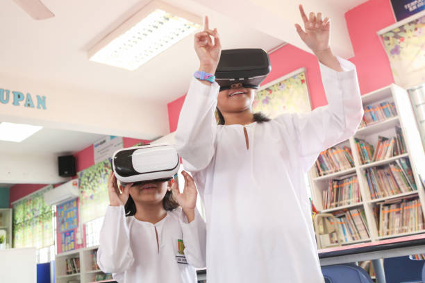 istock Two Schoolgirls Using VR Goggles in School 1185251320