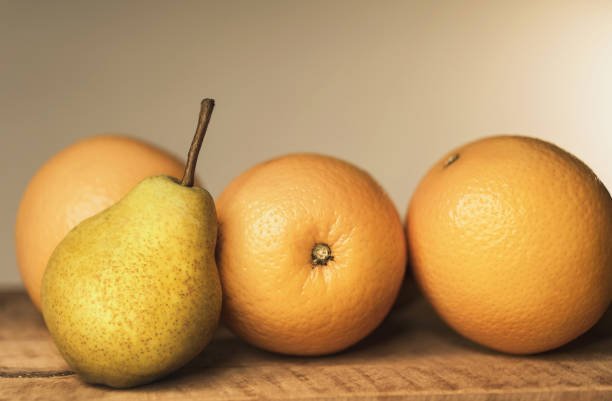 istock Oranges and apples on wooden table, close-up 1185252393
