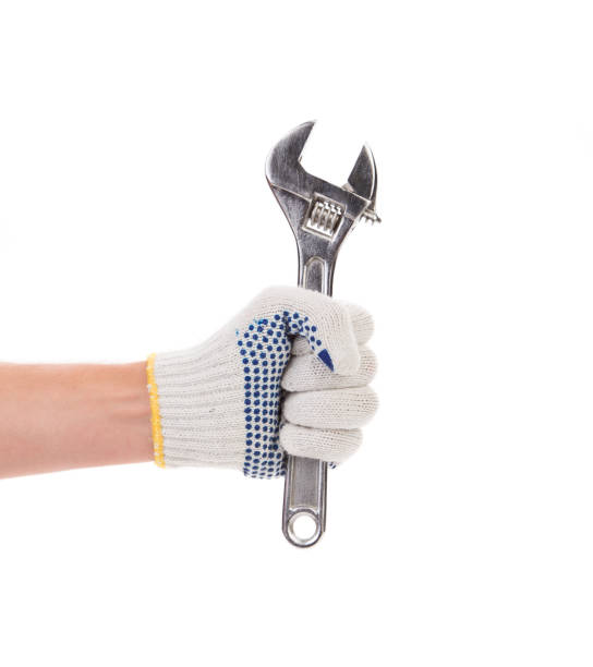 istock Hand in gloves holding adjustable wrench. 1185252885