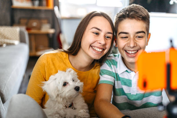 istock Teenage siblings with dog taking selfie 1185252931