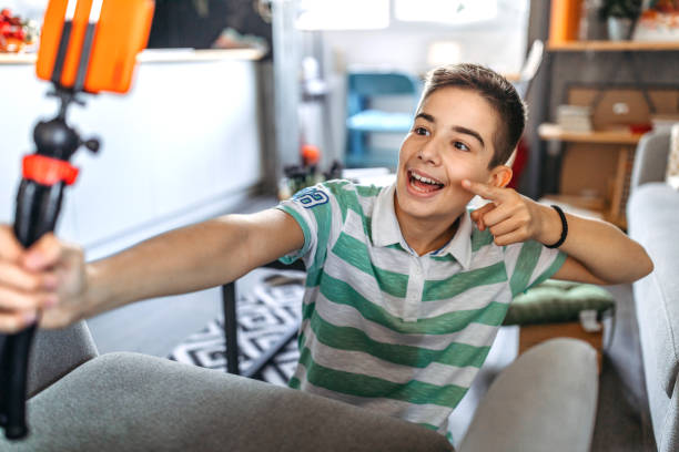 istock Teenage boy pointing at camera while taking selfie 1185252949
