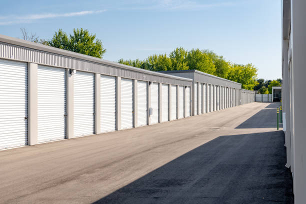 istock Row of storage units with garage doors with trees 1185253689