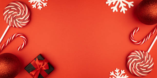 istock Christmas composition. Gift box, baubles, candy, lollipop candies, red decorations on red background. Christmas, winter, new year concept. Flat lay, top view, copy space 1185254306
