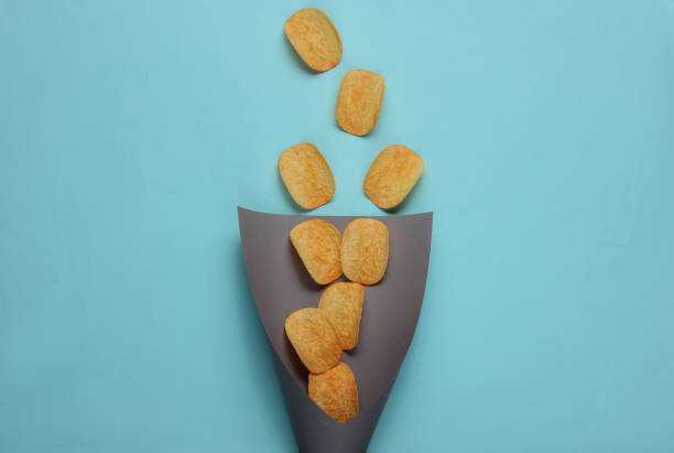 istock Chips slices in paper bag on blue background. Top view 1185255035