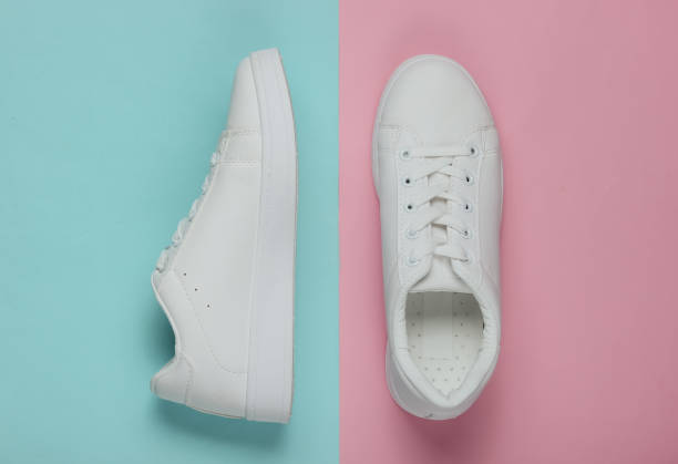istock Stylish white sneakers on pink blue pastel background. Top view 1185255118