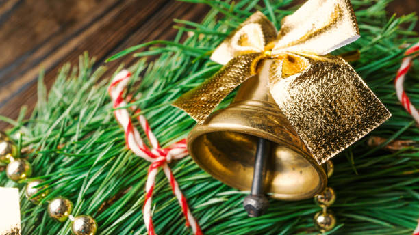istock Christmas bell with golden bows on spruce branches. Christmas decorations, New Year, macro. 1185255861