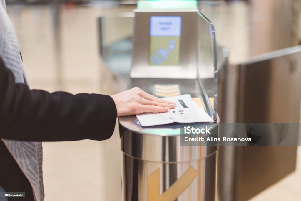 Electronic Boarding pass and passport control in the airport - hand with boarding pass at the turnstile. Electronics Industry Stock Photo