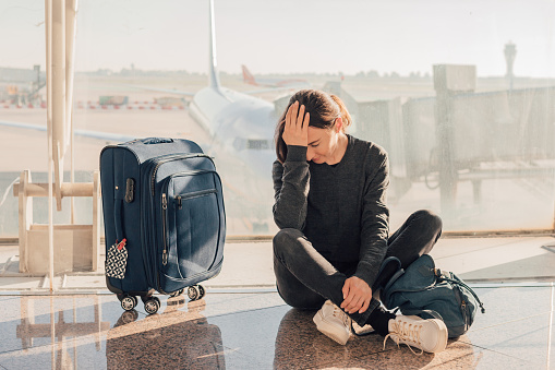 Triste (cansada) mujer sentada en el aeropuerto - perdido o cancelado concepto de vuelo. photo