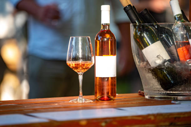 istock Rose wine bottle and glass on a wooden table 1185256867
