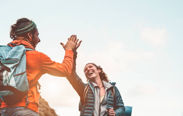 istock Happy friends stacking hands while doing trekking excursion on mountain - Young tourists walking and exploring the wild nature - Trekker, team, hike and travel people concept 1185257084