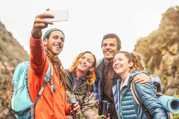 счастливые друзья, принимающие фото селфи с мобильной камерой смартфона в горах - группа молодых людей походы и весело провести время с нов� - trail ride стоковые фото и изображения