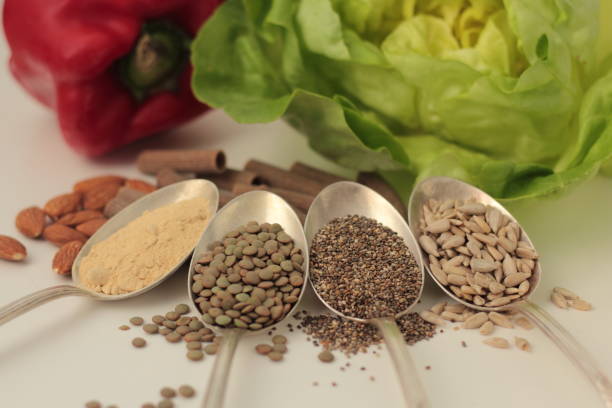 PCOS diet Sample foods from low-GI PCOS (Polycystic Ovary Syndrome) diet. Lentils, chia seeds, sunflower seeds, maca powder, almonds, buckwheat pasta, bell pepper and lettuce. polycystic ovary syndrome photos stock pictures, royalty-free photos & images