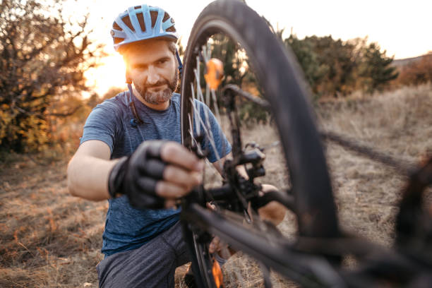 istock Mid adult man repairing broken bicycle 1185257378