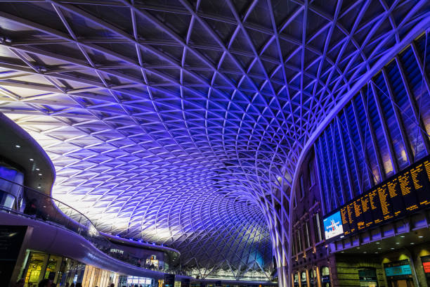 Commuters walking under the modern ceiling inside the departure concourse of King’s Cross Station in central London.