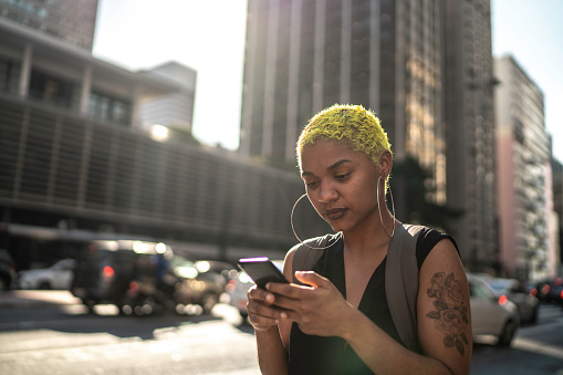 Young woman using smartphone at city