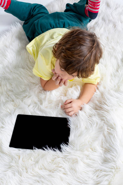 istock Little Boy working tablet on carpet 1185258858