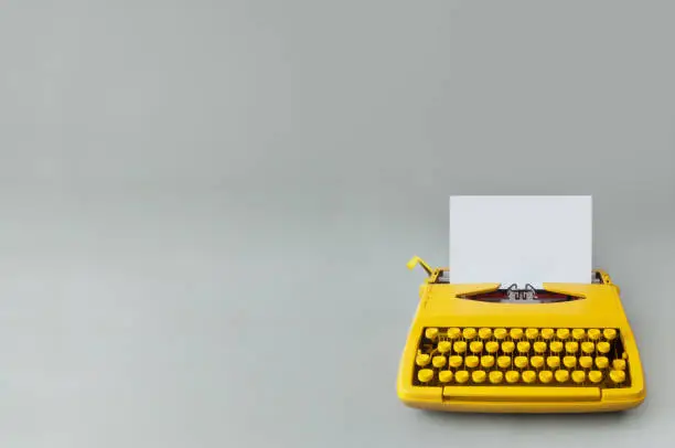 Retro typewriter on a grey paper backdrop