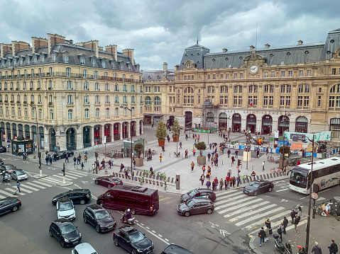 Paris, France - May 10, 2019:  Square in front of Gare Saint-Lazzare with crowds of people and cars moving around.