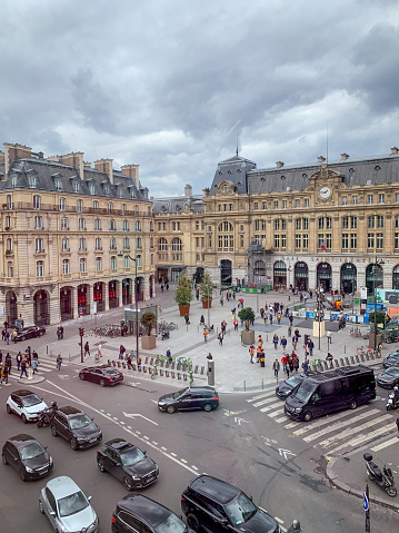 Paris, France - May 10, 2019:  Square in front of Gare Saint-Lazzare with crowds of people and cars moving around.