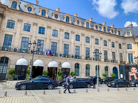 Paris, France - May 11, 2019:  Hotel Ritz on Place Vendome, Paris. Few people at the entrance around parked cars.