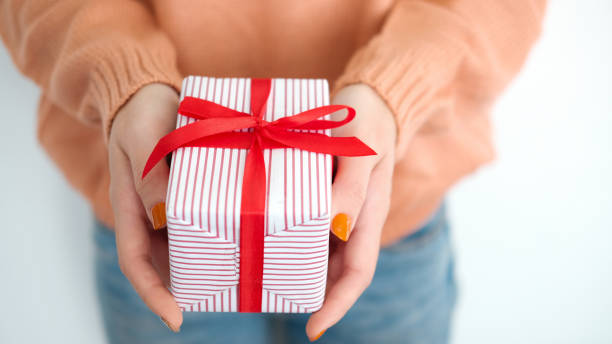 istock Closeup female hands holding gift box. 1185265359