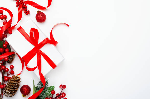 istock Present box, berries and pinecones top view background. Christmas gift. Festive backdrop with copyspace. Xmas composition with holly ilex twigs and New year tree toys. Winter holidays concept 1185266431