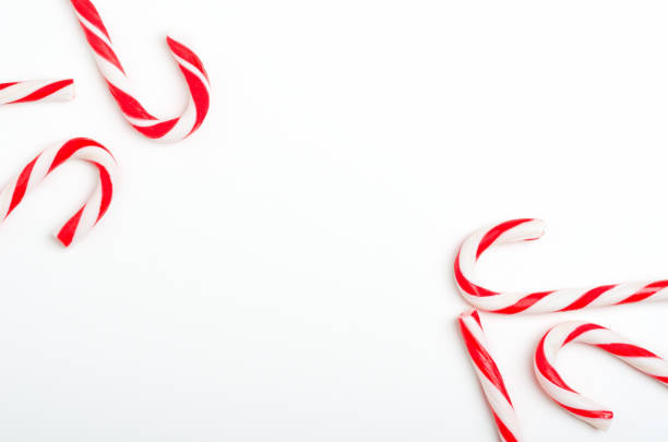 istock Blank frame with Christmas candy canes top view. New Year lollipops on white background. Winter holidays backdrop with copyspace. Xmas confection composition with decorative elements. 1185266470