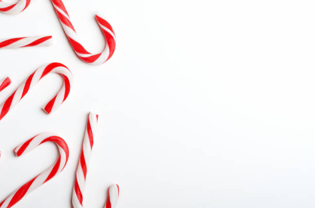istock Blank frame with Christmas candy canes top view. New Year lollipops on white background. Winter holidays backdrop with copyspace. Xmas confection composition with decorative elements. 1185266517