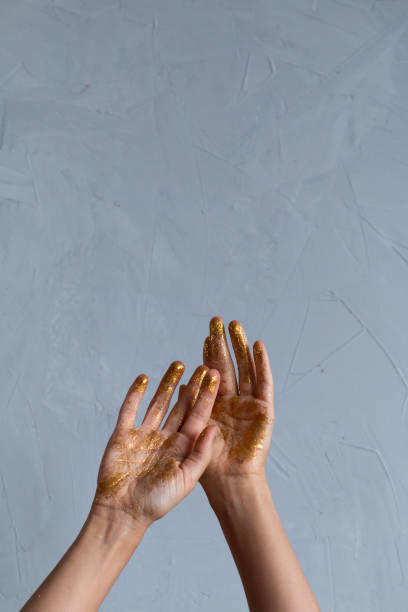 istock Woman’s hand with a golden paint 1185267148