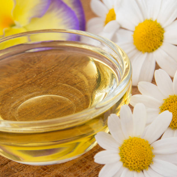 istock Honey in glass bowl with flowers as background 1185268200