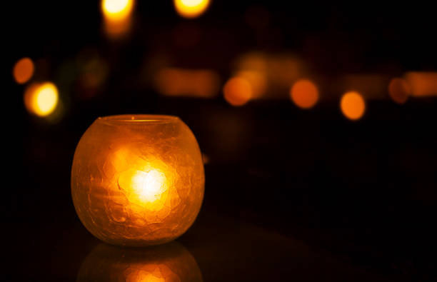 istock Candle holder glass on a table with lights on dark background. Copy space. 1185268461