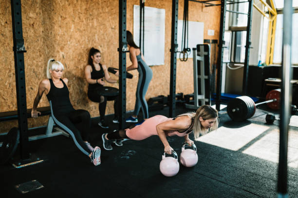 istock Women exercising and lifting weights in the gym 1185269486