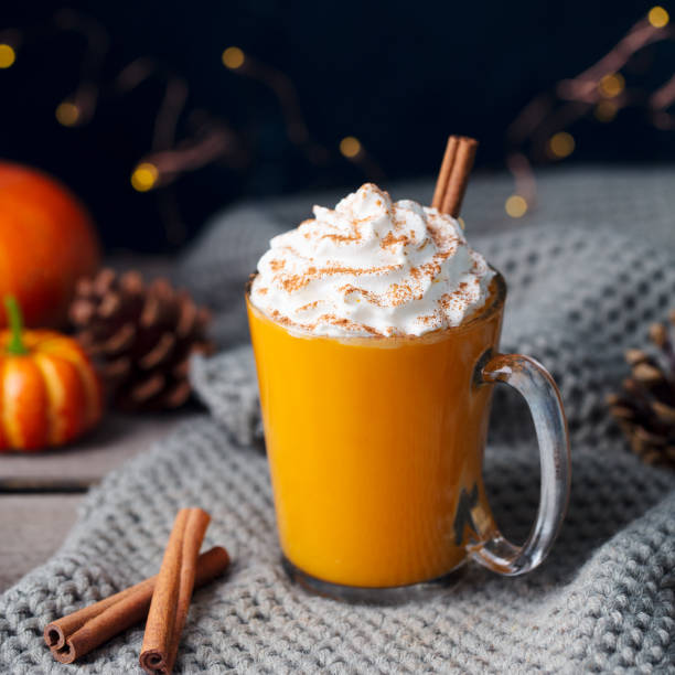 pumpkin latte with spices. boozy cocktail with whipped cream. knitted scarf background. - latté pumpkin spice coffee imagens e fotografias de stock