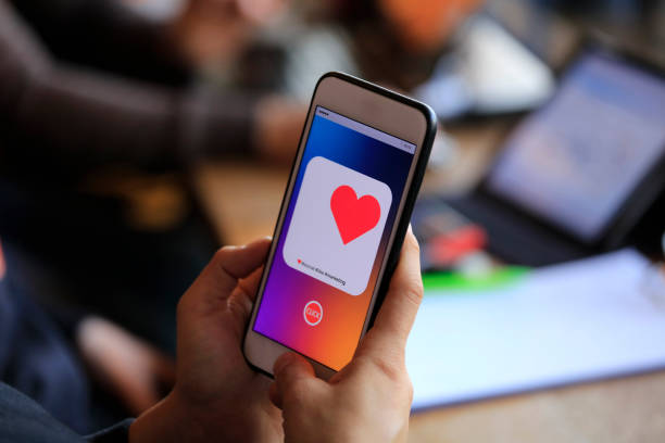 istock Hand holding smart phone with sending heart 1185277866