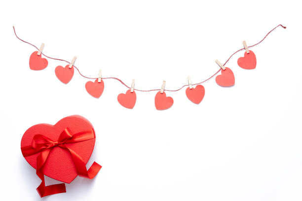 istock Red hearts garland hanging on white background 1185278402