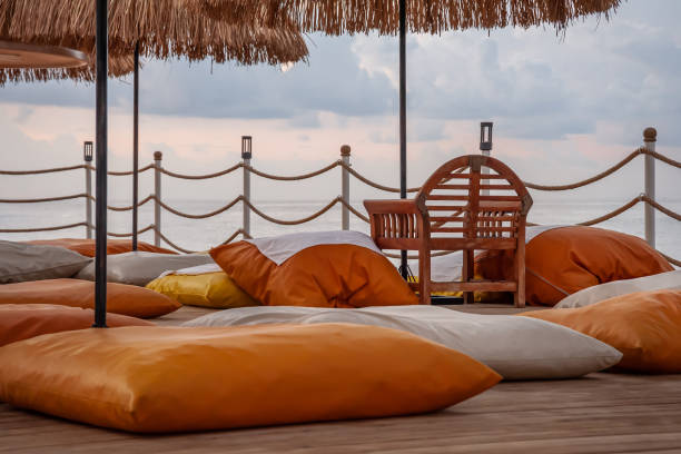 Straw umbrellas and pillows on the seashore pier