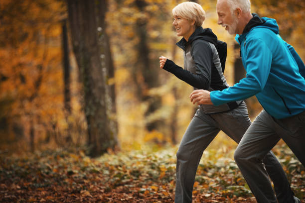 istock Senior couple jogging in a forest. 1185281710