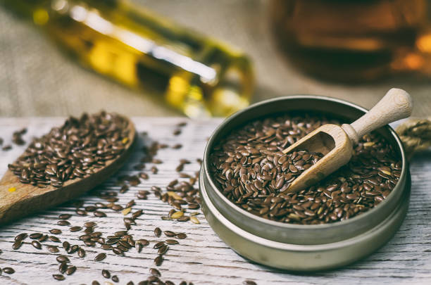 sementes de linho e óleo de linhaça no fundo de madeira - flax seed - fotografias e filmes do acervo