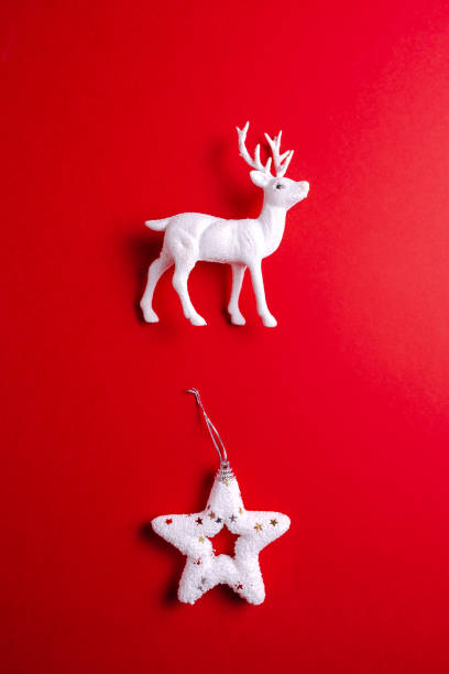 istock White reindeer toy with christmas star on red background. 1185284489