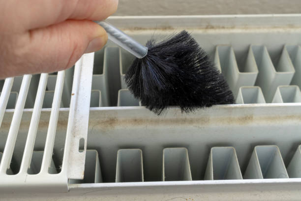 cleaning the heater or radiator with a brush stock photo
