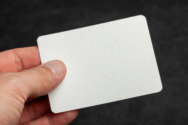 istock Man holds in his hand a blank template card on black background 1185289233
