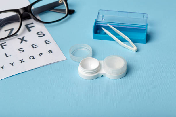 istock Flat composition with contact lenses, table for eye examination. Accessories for ophthalmologists. Glasses and lenses for vision correction on a blue background 1185290938